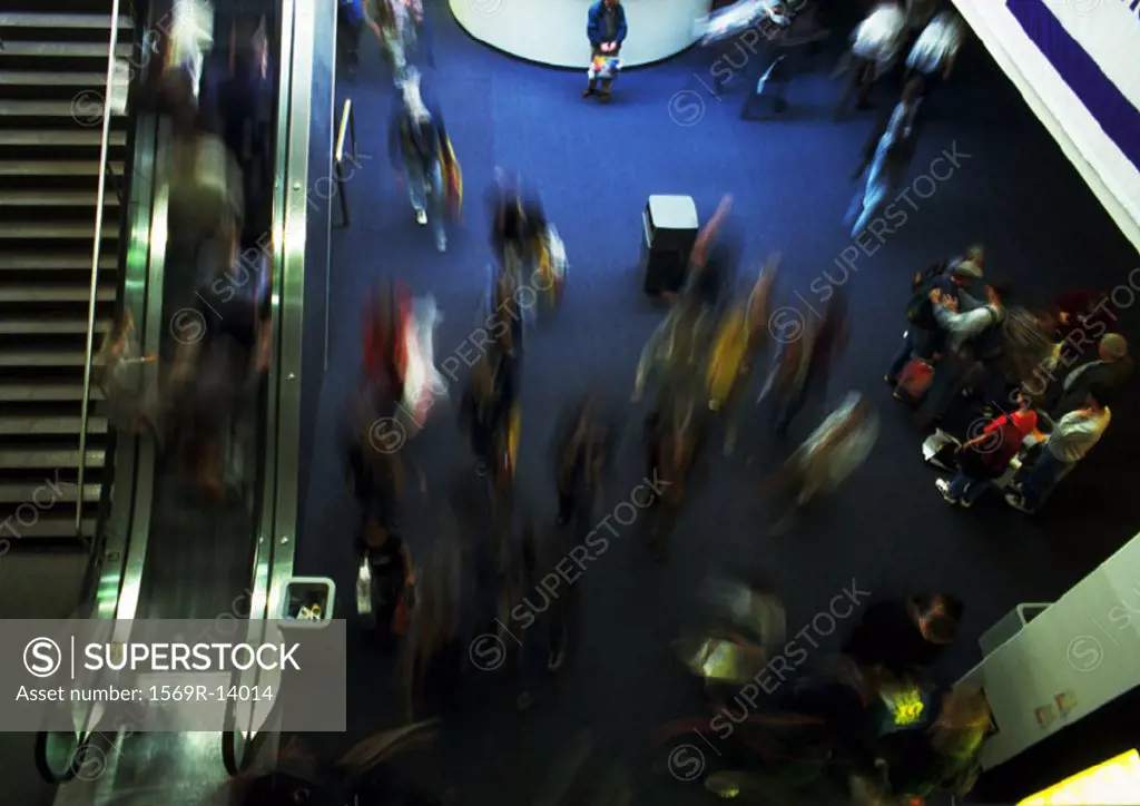 Crowd inside building, next to escalator, blurred motion, high angle view