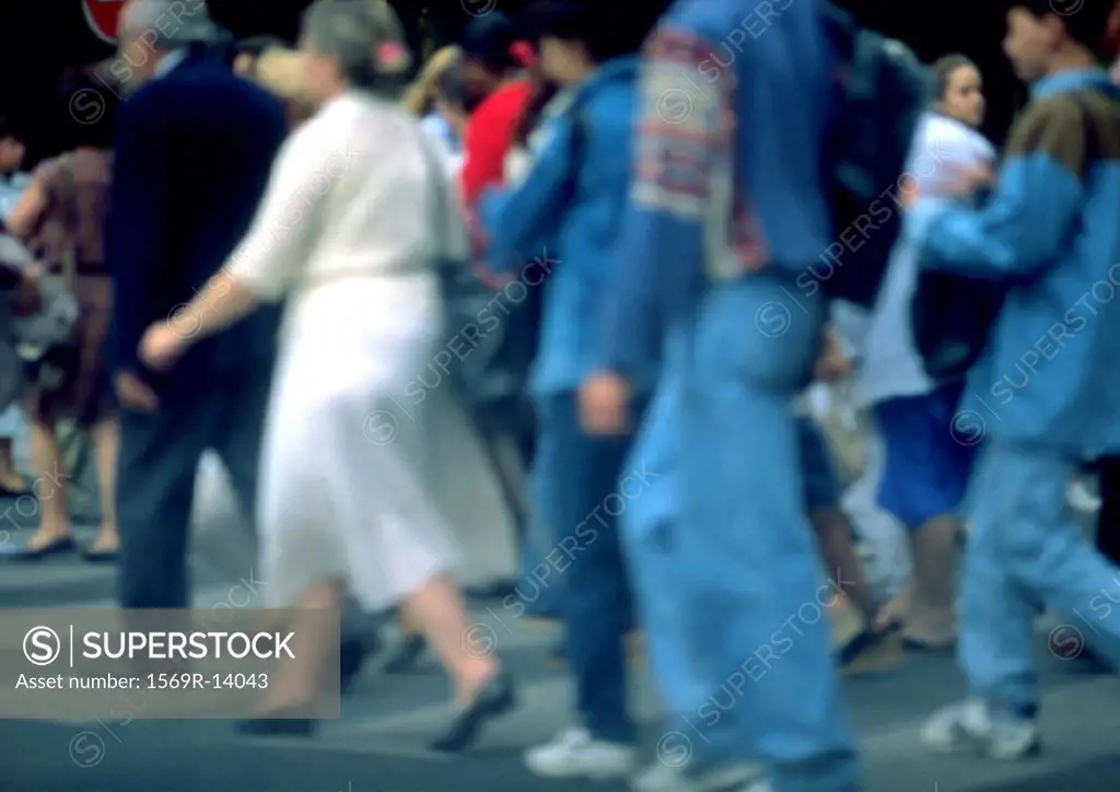Crowd walking on sidewalk, blurred