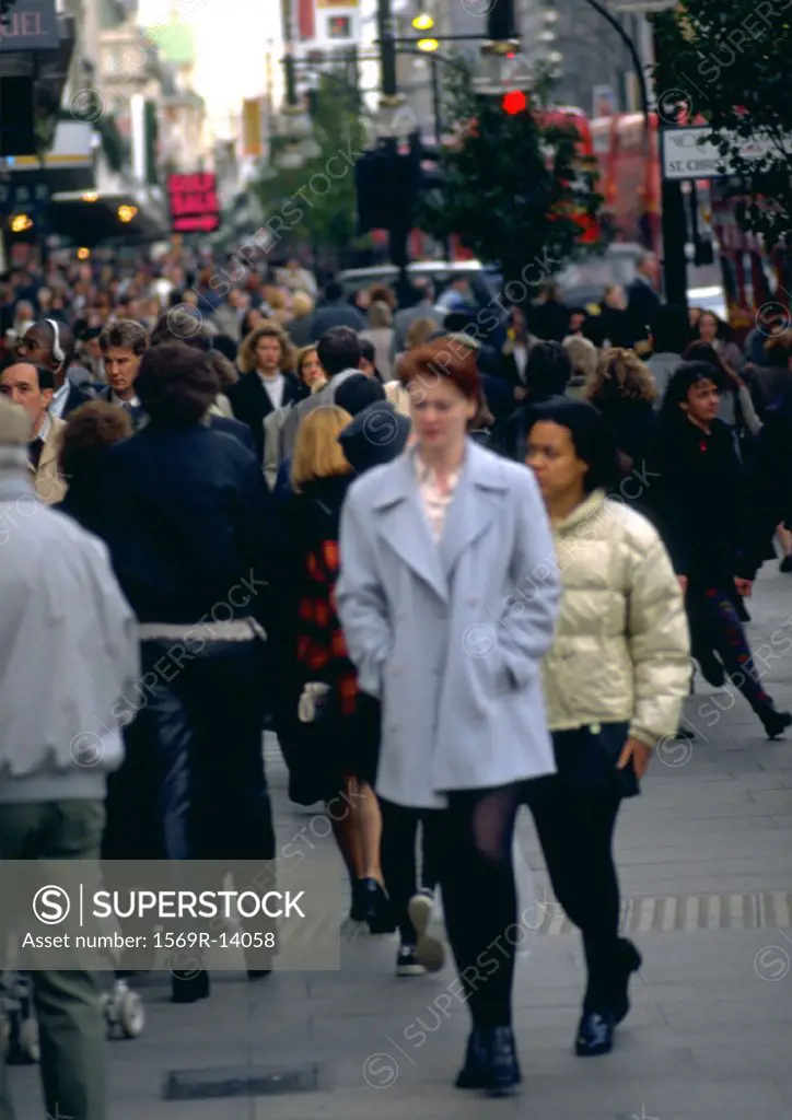 Crowd of people walking down a street, blurred