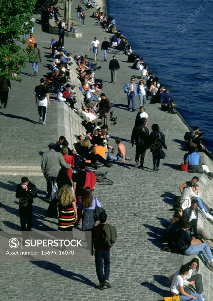 People walking and sitting by water