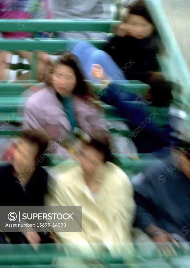 Group of people sitting in bleachers, motion, blurred