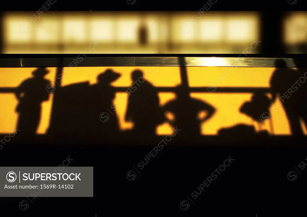 Shadows of people standing behind railing, low angle view