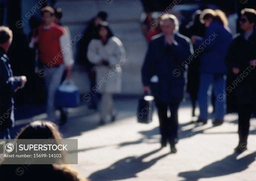 People walking on sidewalk, blurred