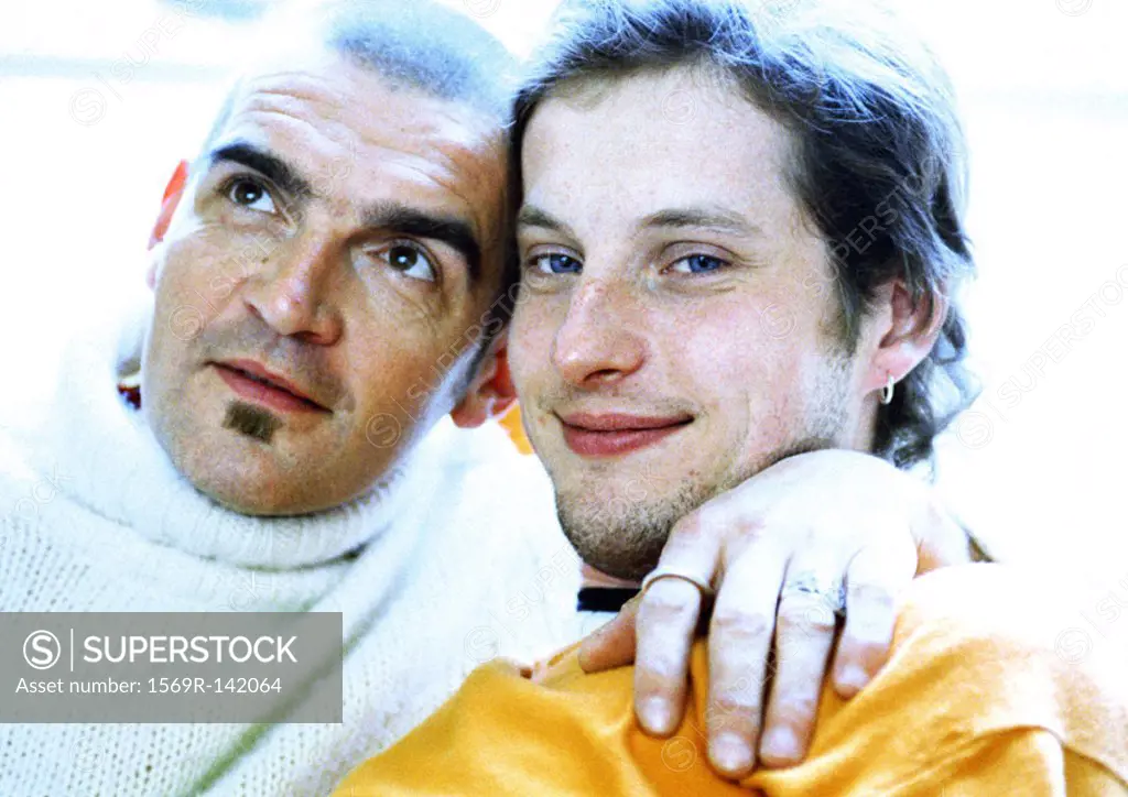 Two men sitting, man´s arm around the other´s neck, portrait