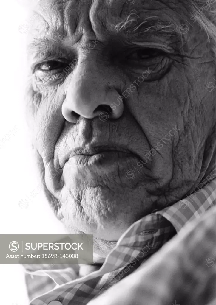 Elderly man frowning at camera, close-up, portrait, b&w