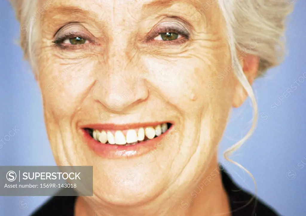 Mature woman smiling at camera, close-up, portrait