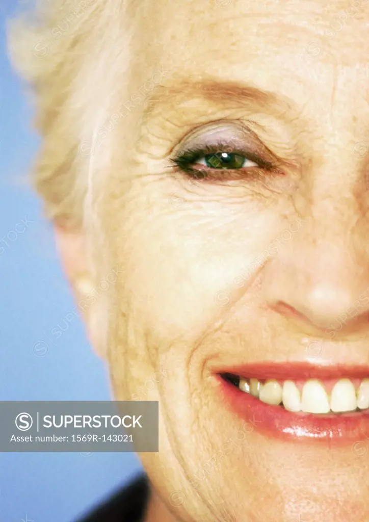 Mature woman smiling at camera, close-up, partial view