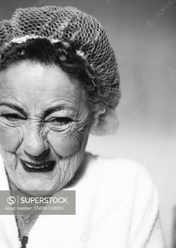 Elderly woman wearing hair net, smiling, portrait, close-up, b&w