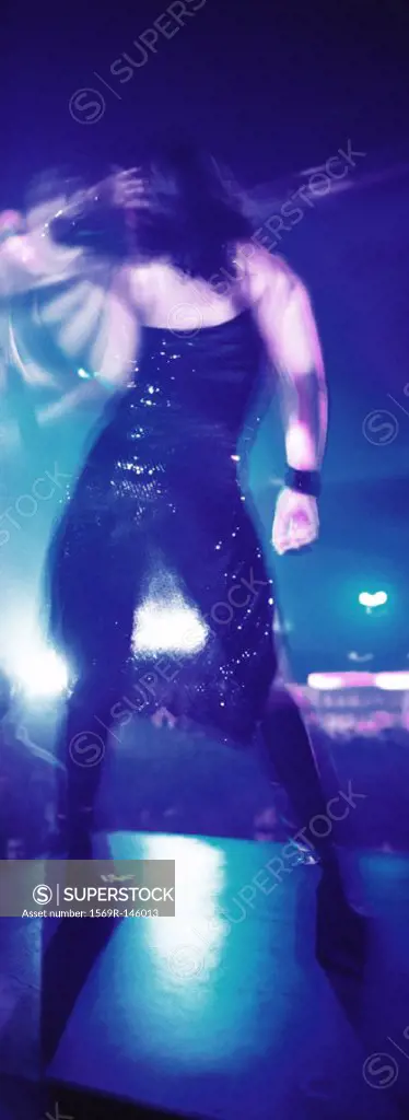 Person dancing in nightclub, rear view