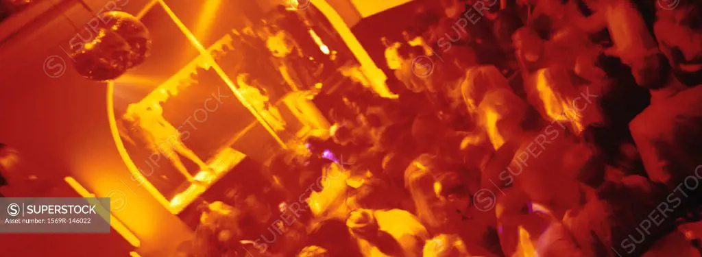 Crowd of people dancing at nightclub, blurred