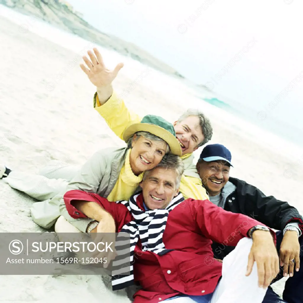 Mature group sitting on beach looking into camera
