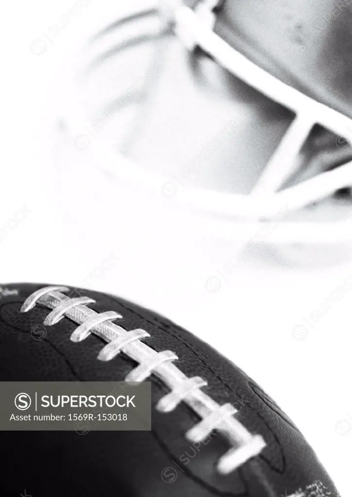 Football and helmet, close-up, b&w