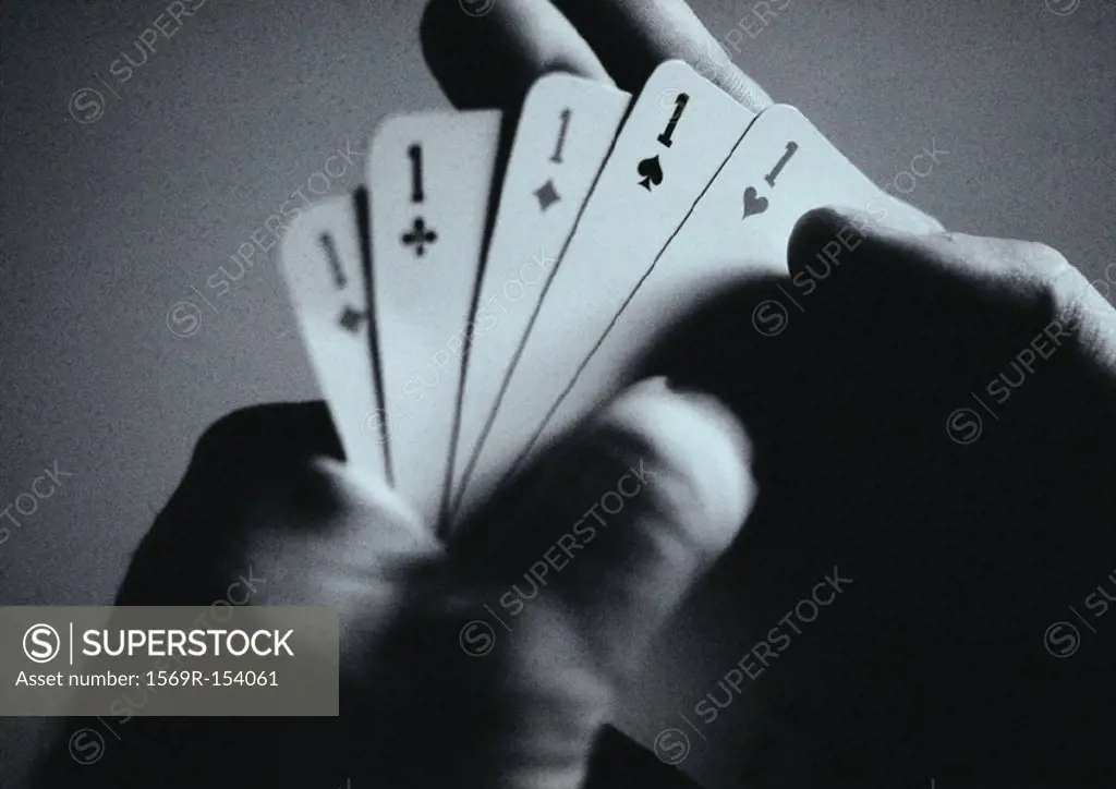 Hands holding playing cards, close-up, b&w
