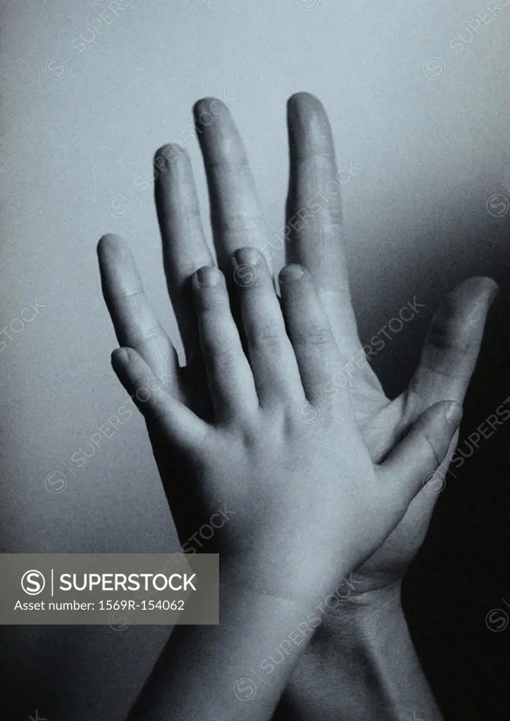 Child´s hand against man´s hand, palm to palm, close-up, b&w