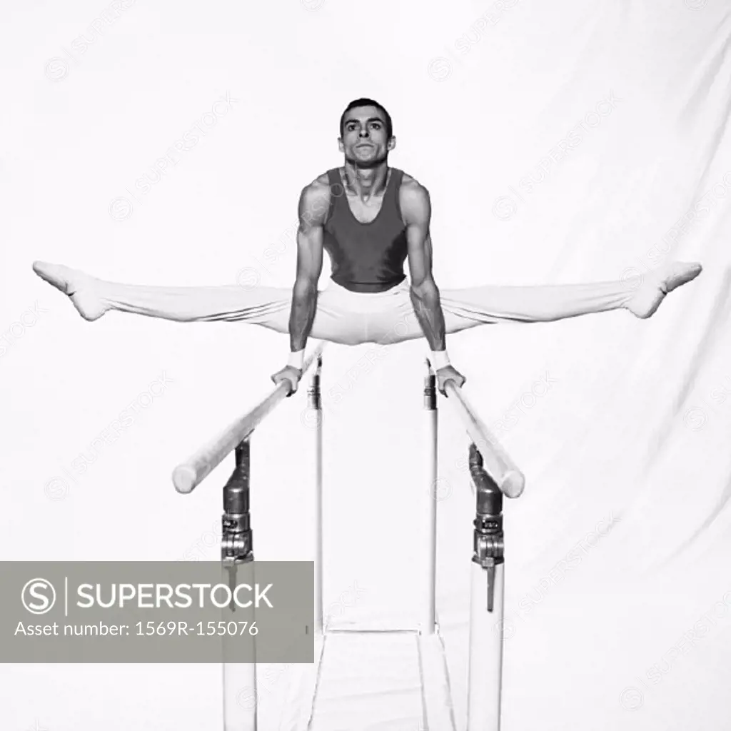 Young male gymnast on parallel bars, b&w