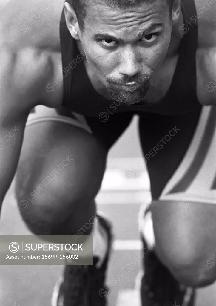Male runner at start of race, close-up, b&w