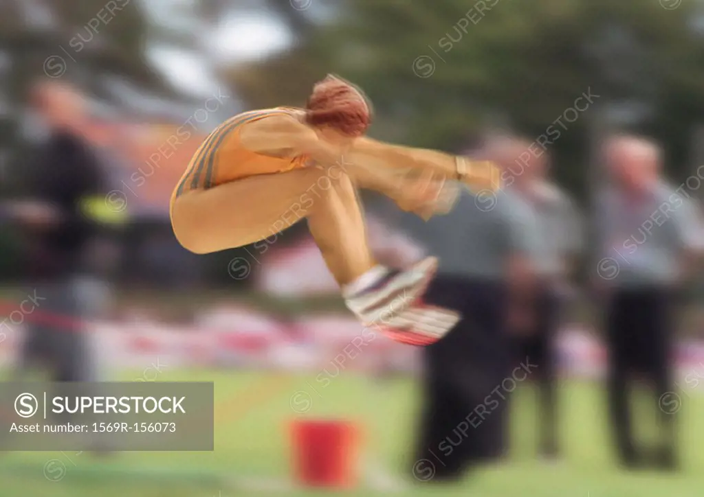 Female long jumper in mid-air, blurred motion