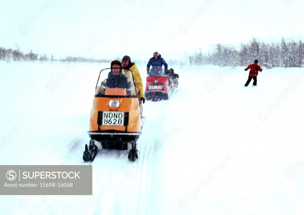 Sweden, people driving snowmobiles in snow