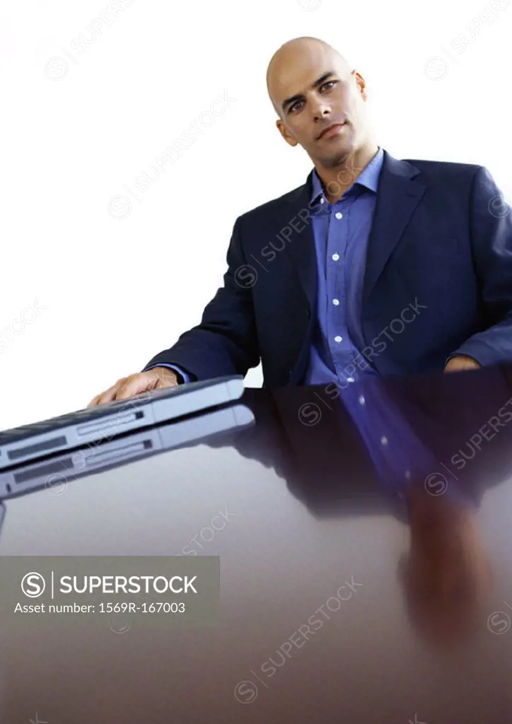 Businessman sitting at desk, portrait