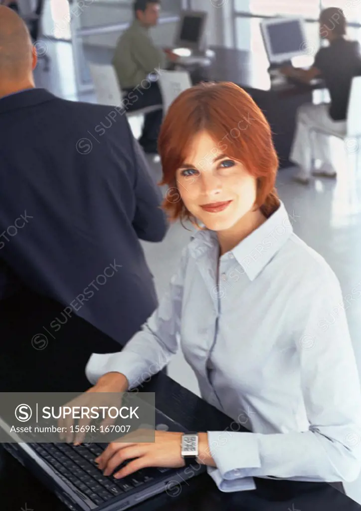 People working in office, businesswoman using laptop computer, portrait