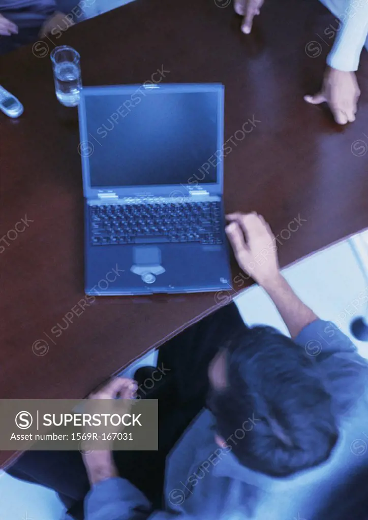 Businessman sitting at desk with laptop computer, elevated view