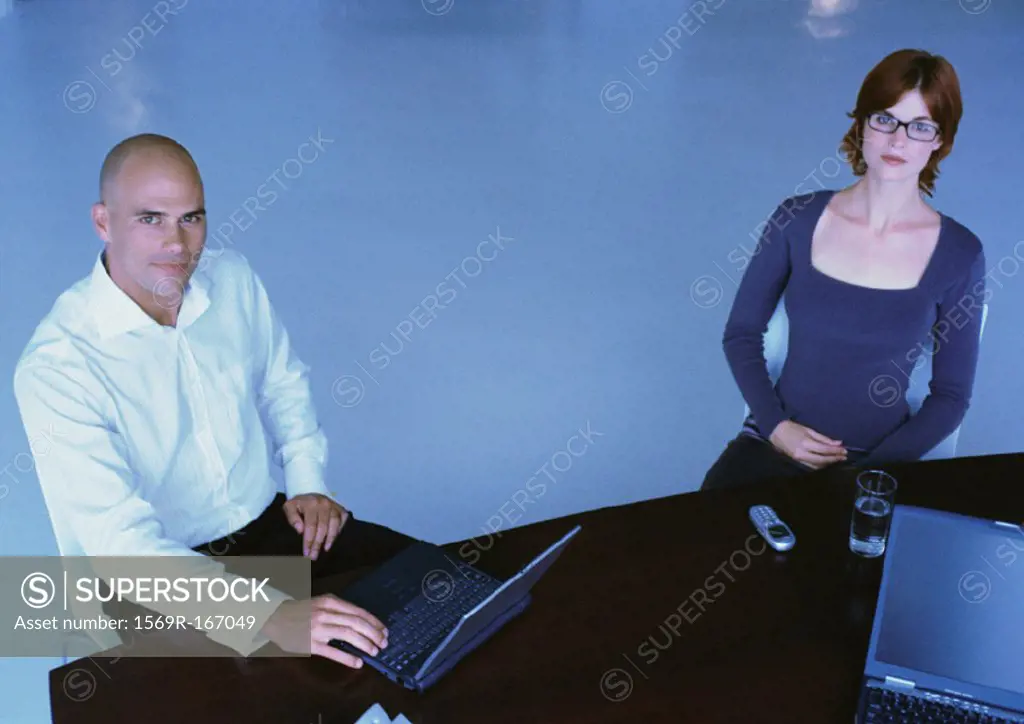 Businessman and woman sitting at desk