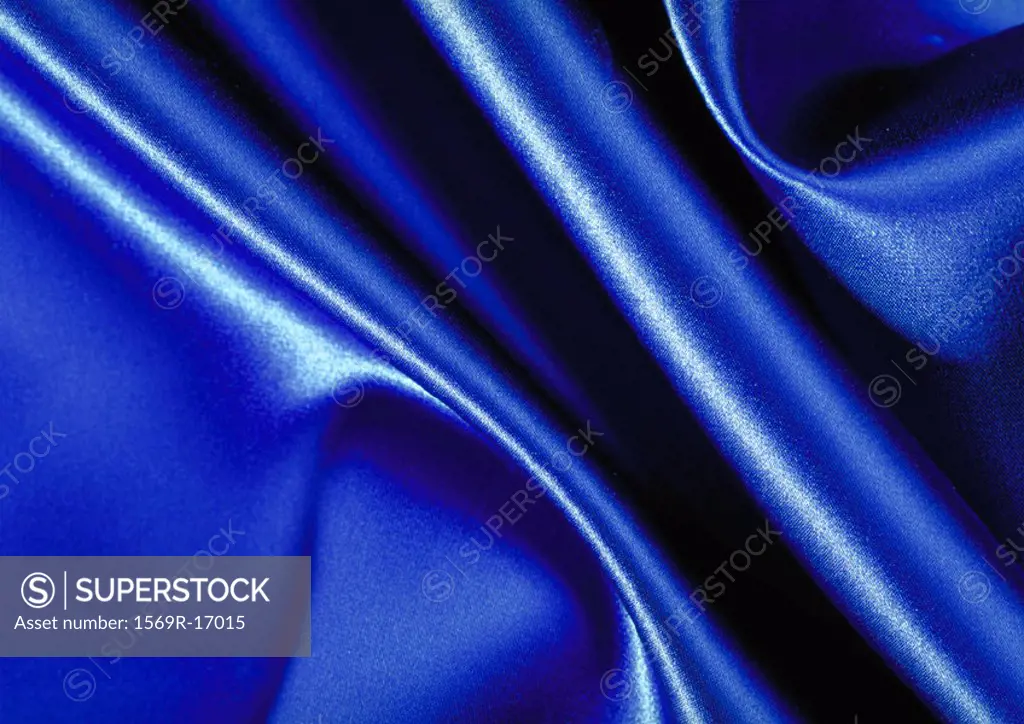 Folds in blue satin, close-up, full frame