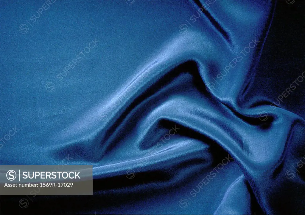 Folds in silky blue fabric, close-up, full frame
