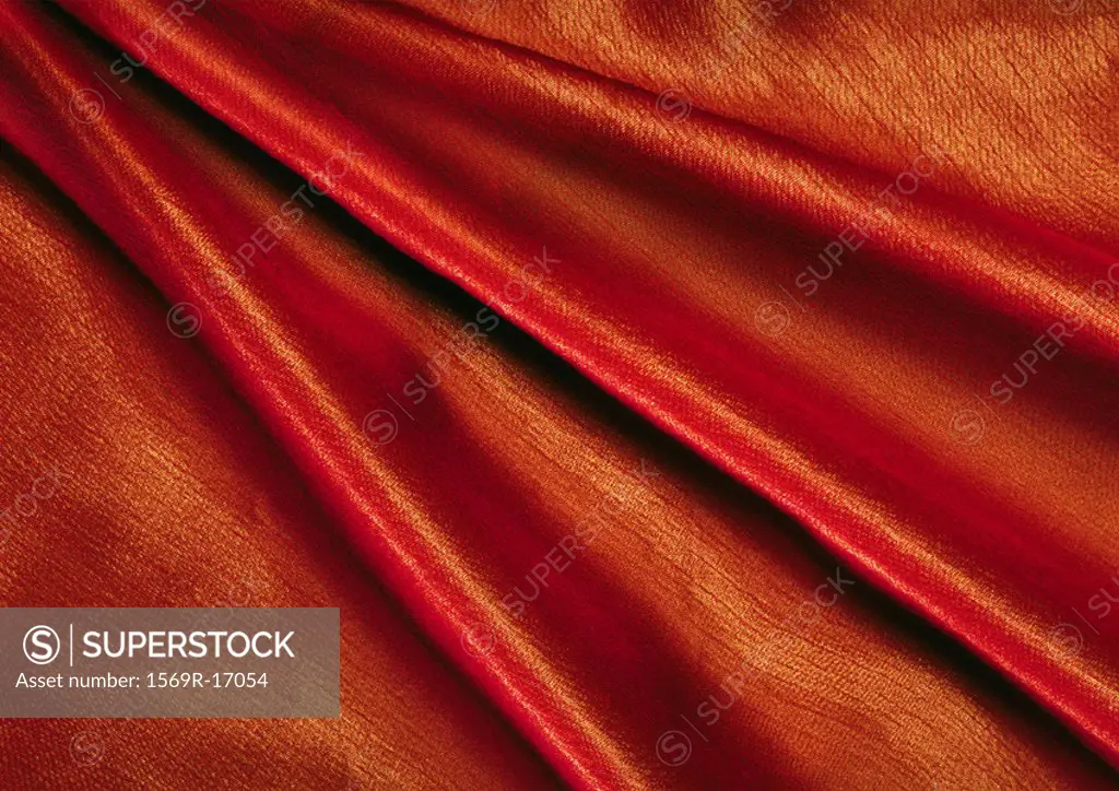 Folds in orange fabric, close-up, full frame