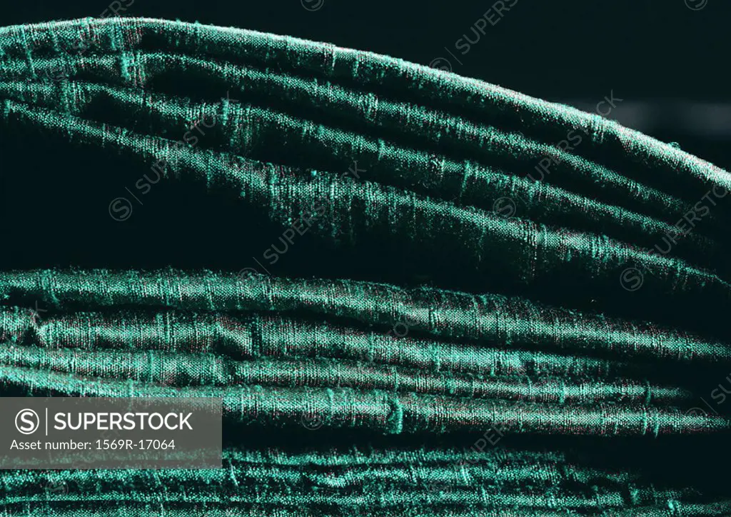 Folds in green fabric, side view, close-up, full frame