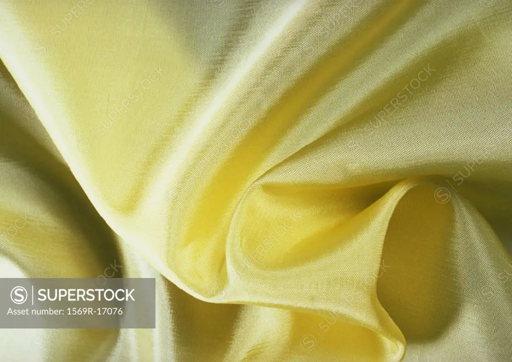Folds in yellow silk, close-up, full frame