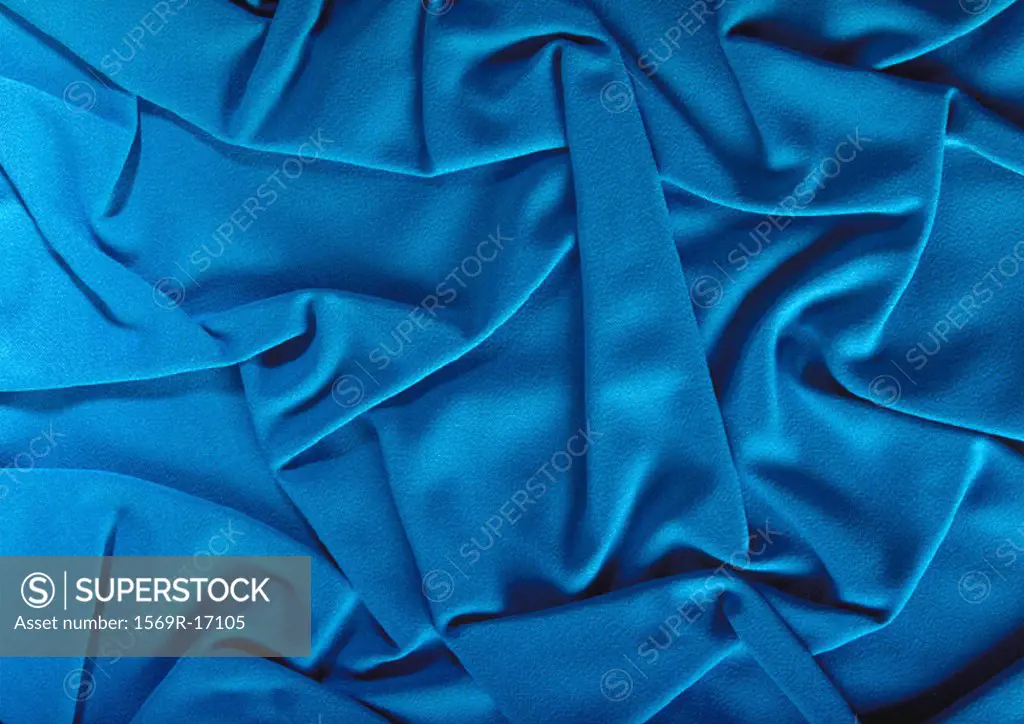 Folds in blue fabric, close-up, full frame