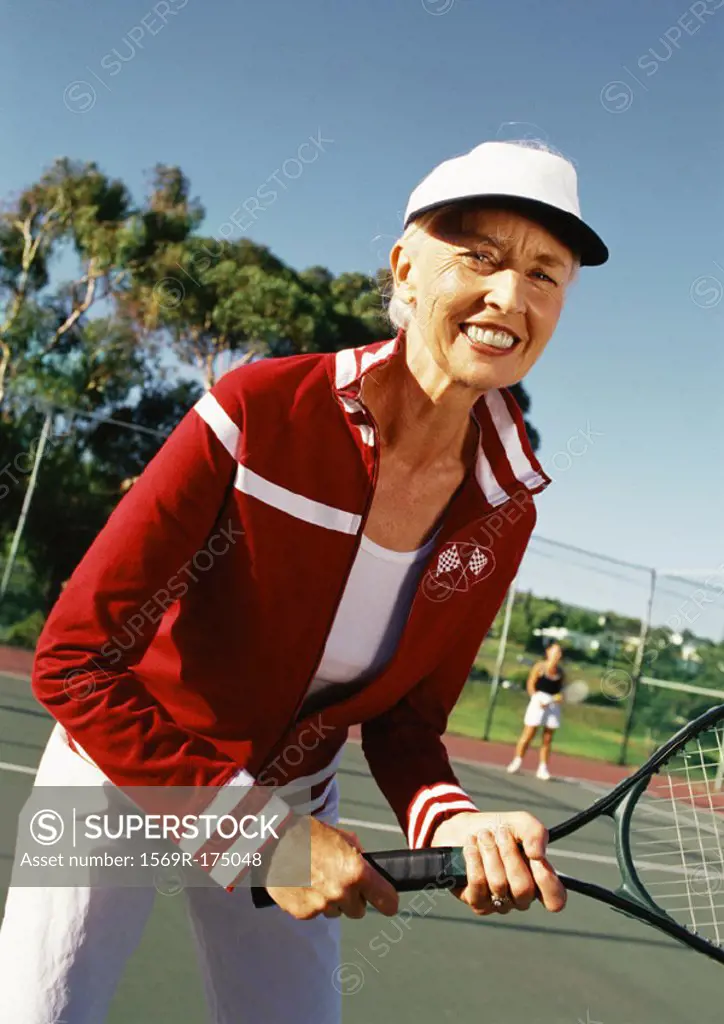 Mature woman holding tennis racket, portrait