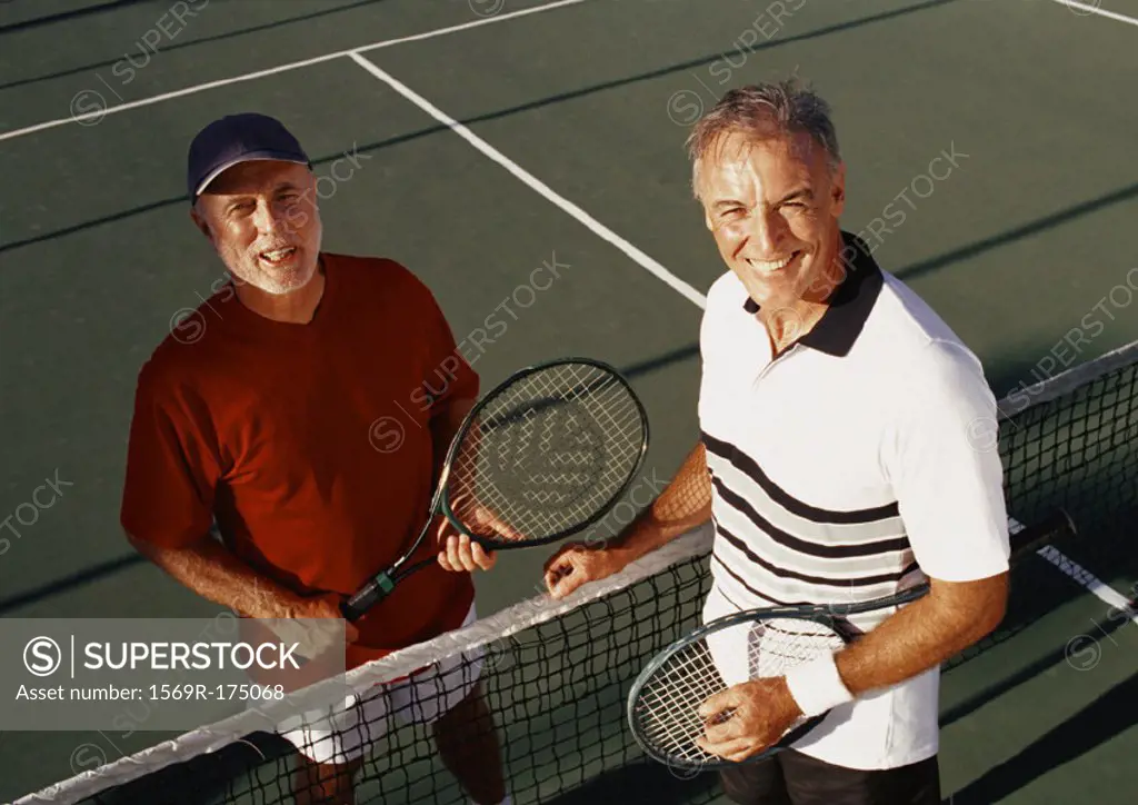Two mature men on tennis court, portrait