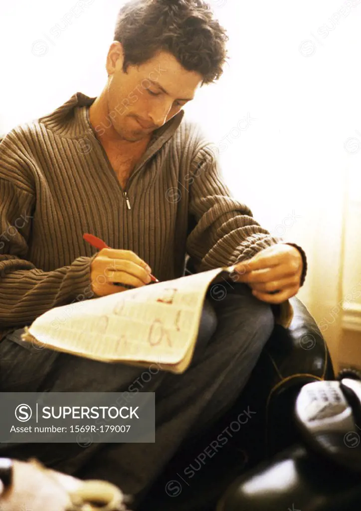 Man writing on newspaper