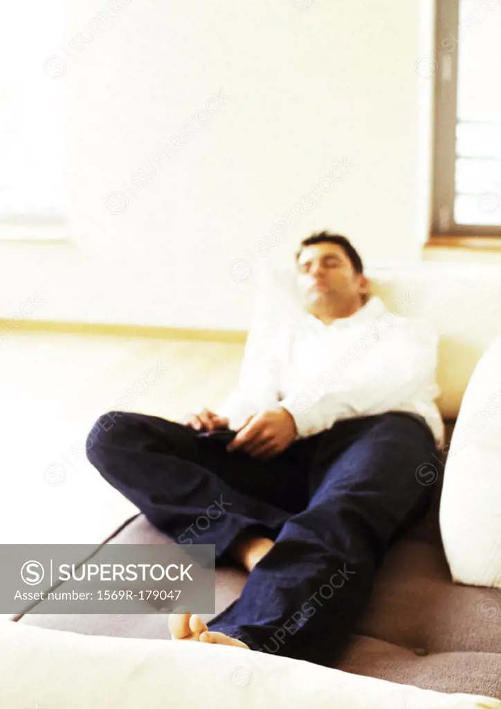 Man lying on sofa, blurred