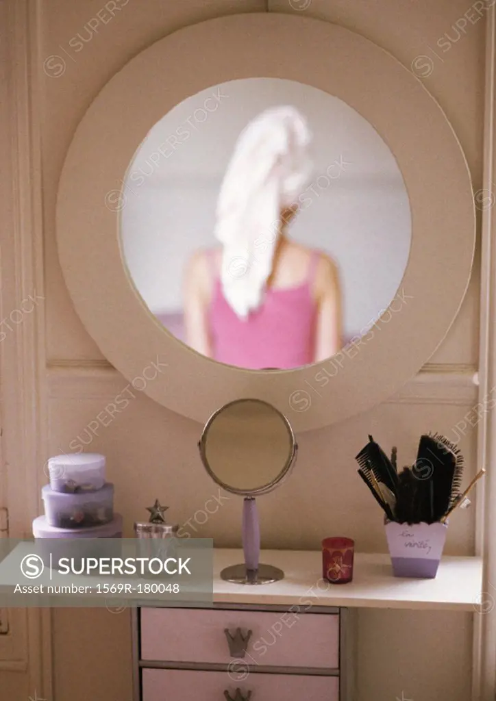 Woman reflected in mirror, rear view