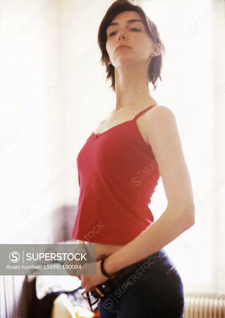 Woman sticking out chest, fastening jeans