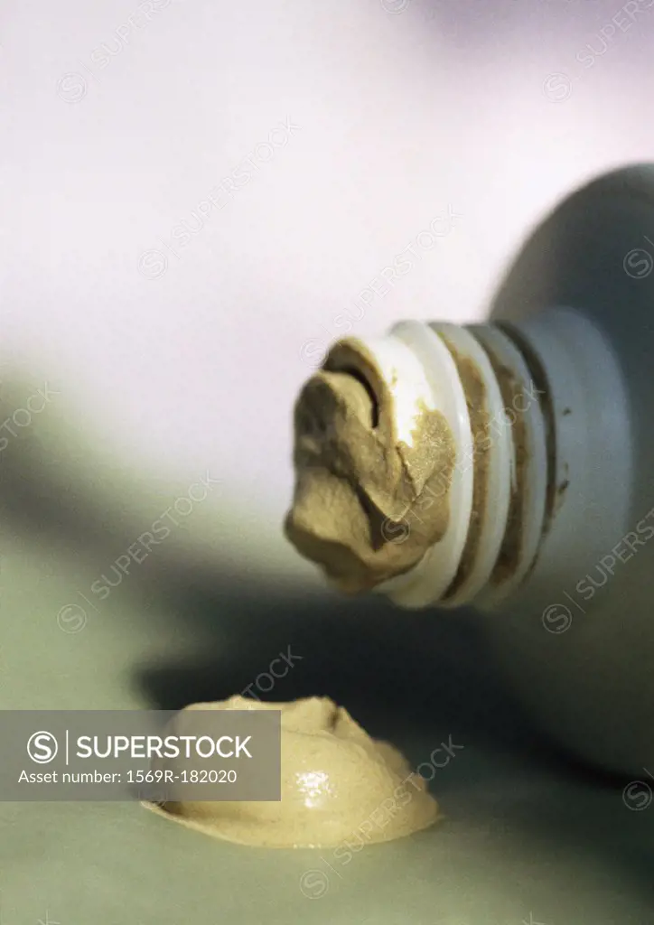 Dab of beauty product and tip of bottle, close-up