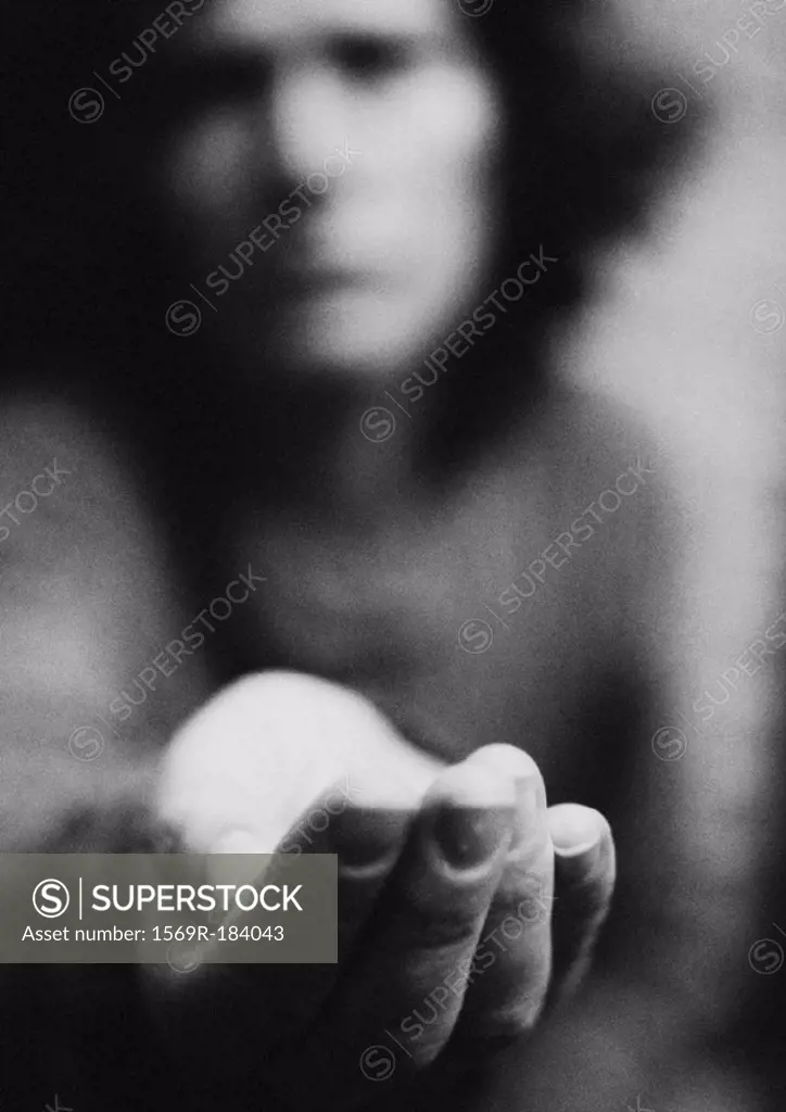 Woman holding hand out, blurred, b&w
