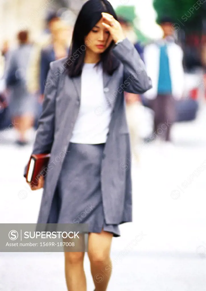 Businesswoman walking with book in hand