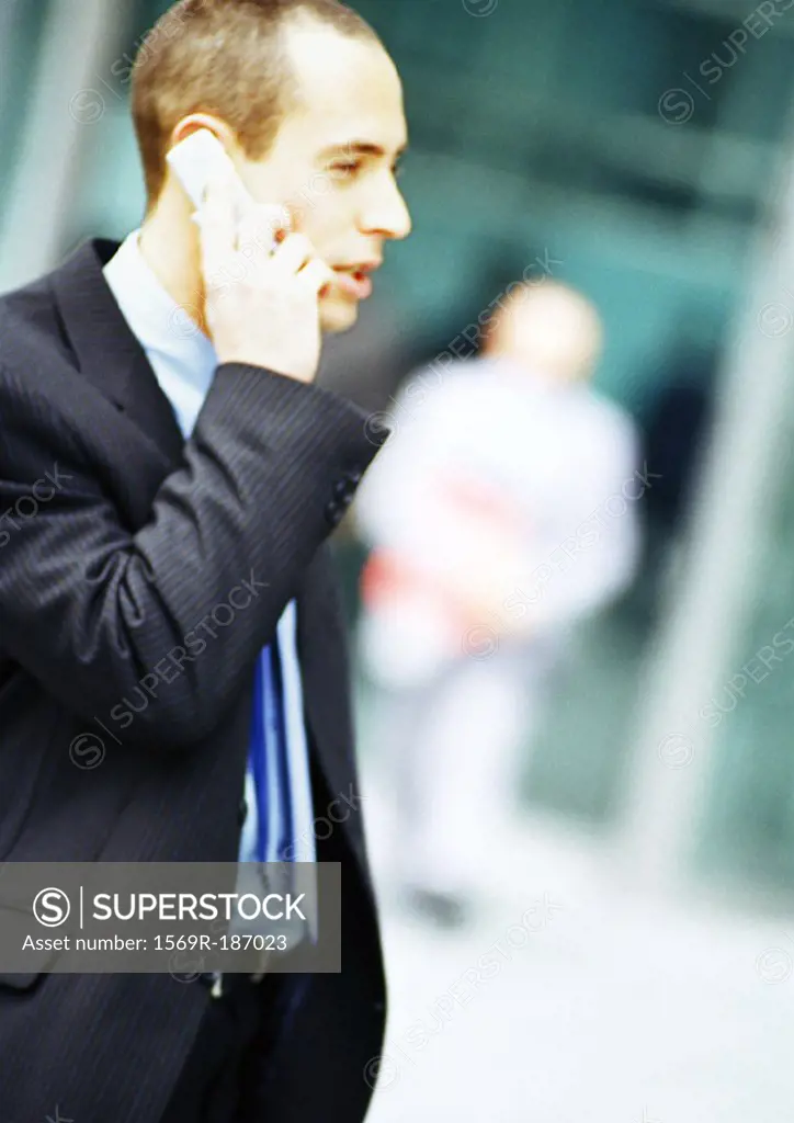 Businessman using cell phone, side view