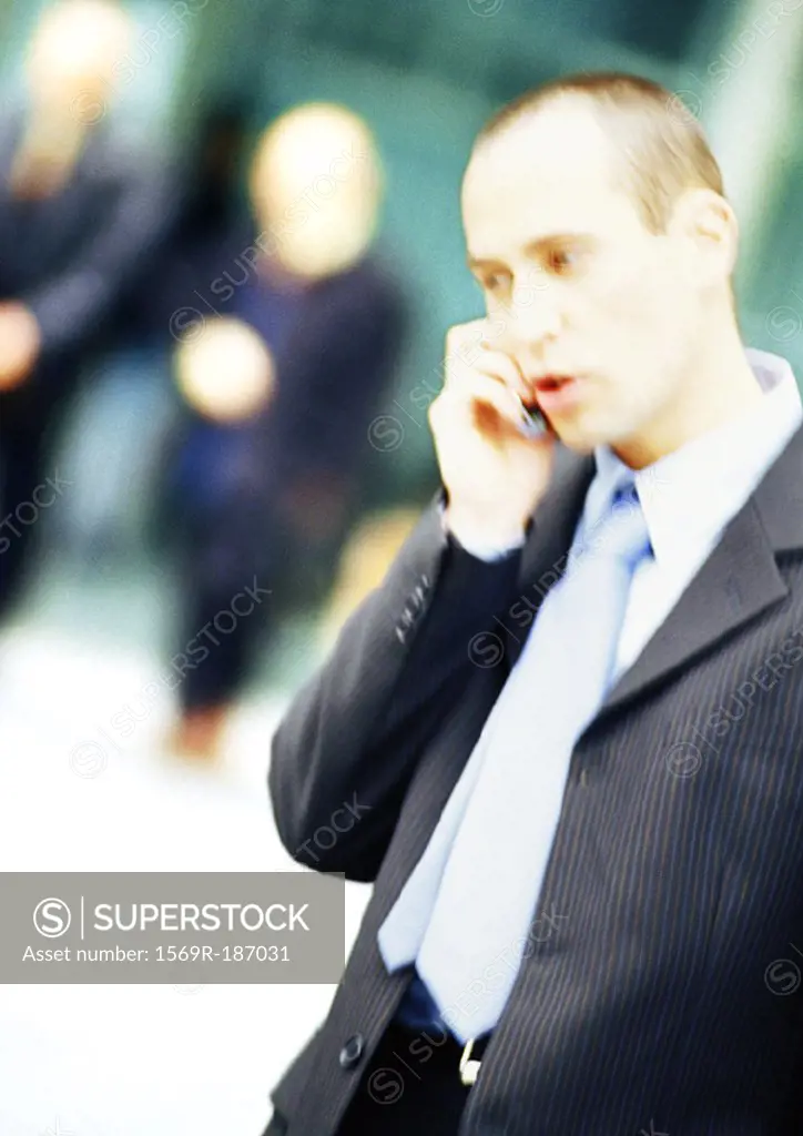Businessman using cell phone, side view