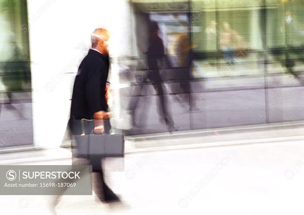 Businessman holding briefcase, blurred