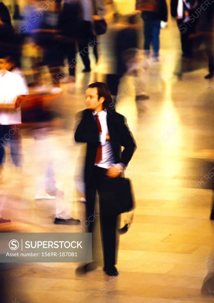 Businessman in crowd, blurred motion