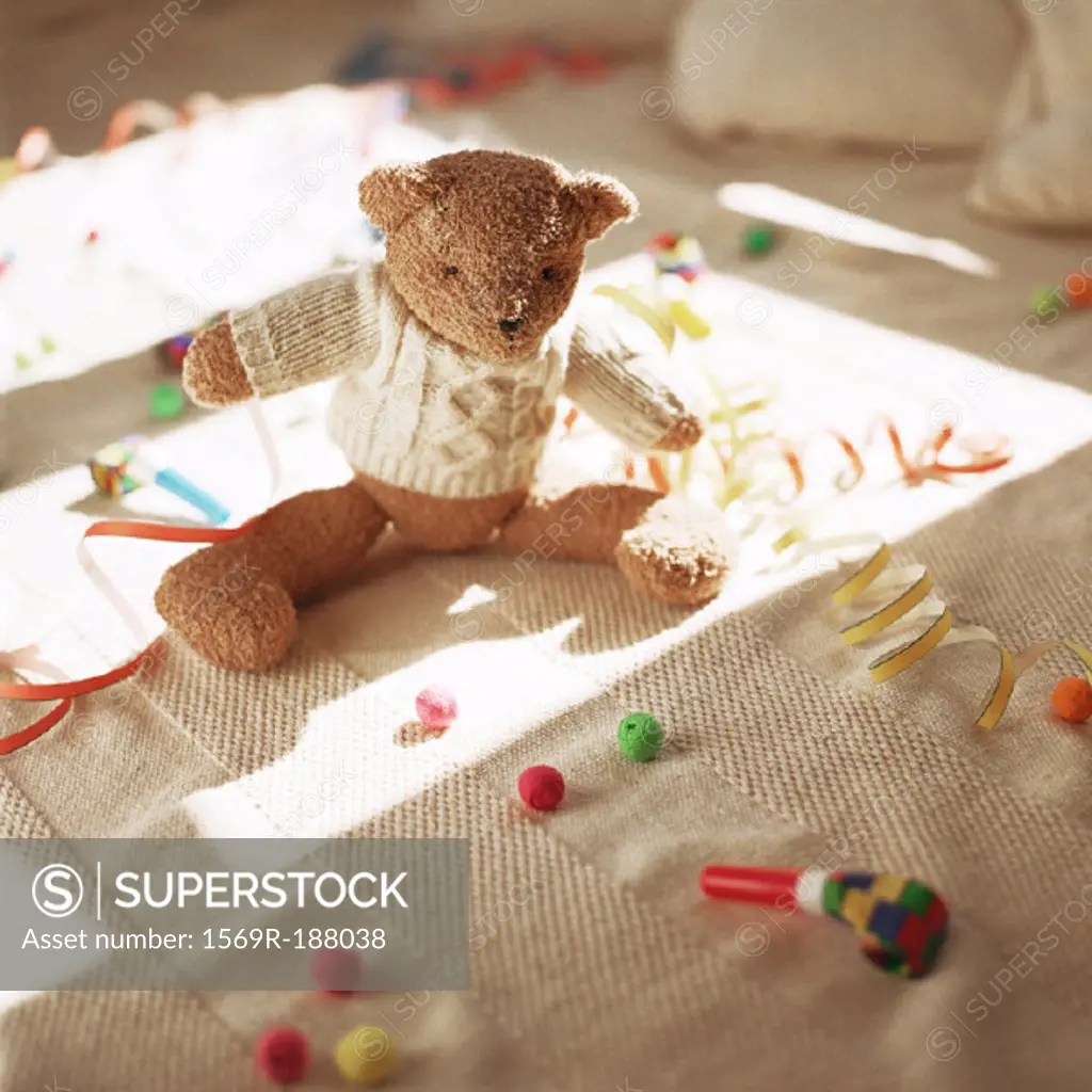 Stuffed teddy bear on floor with party favors