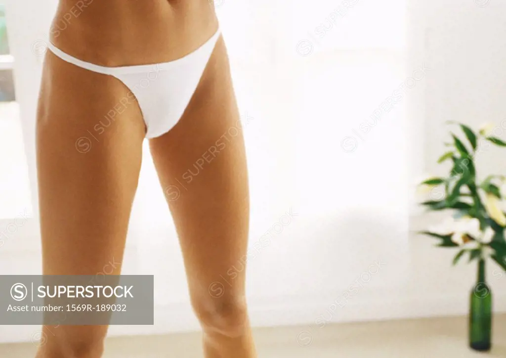 Woman standing in underwear, partial view