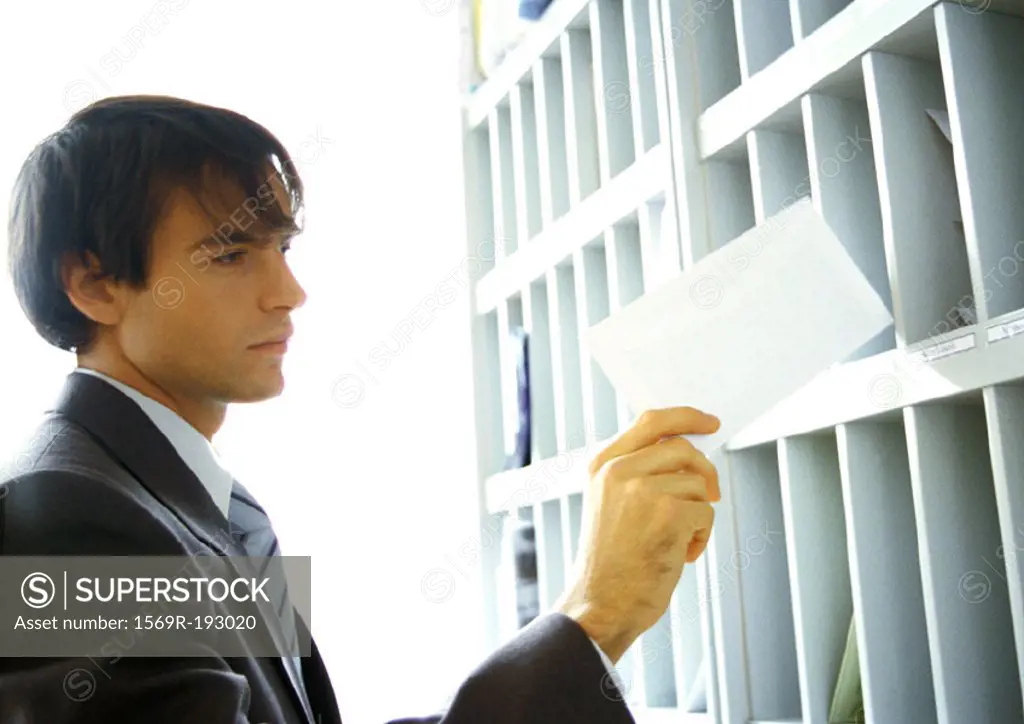 Businessman pulling mail out of slot