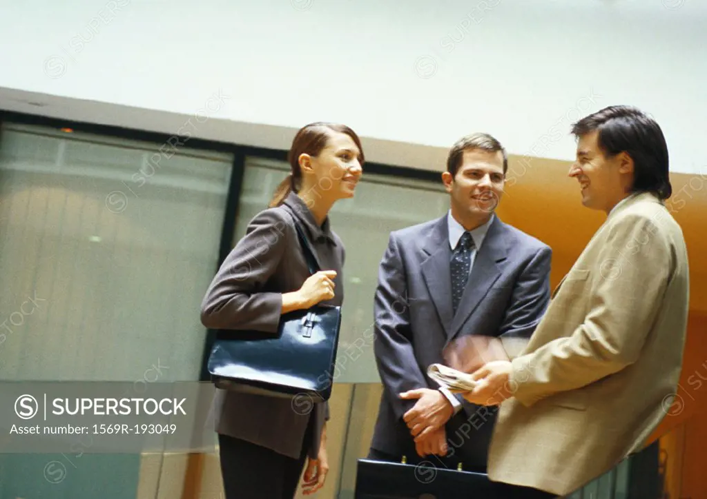 Three businesspeople standing and talking