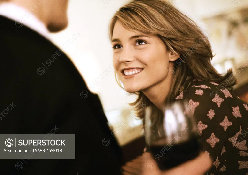 Young woman smiling at man with drink
